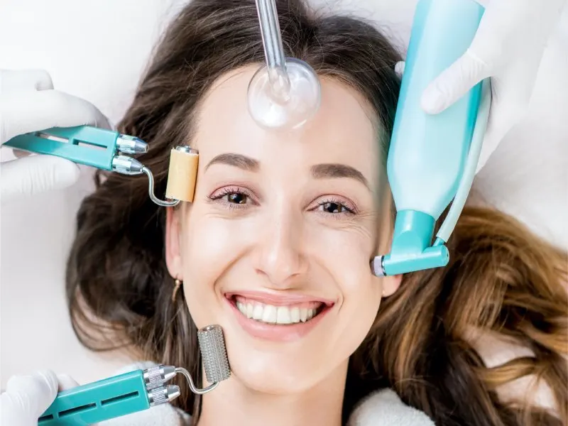 Smiling woman receiving skin treatment at Periwinkle Clinic